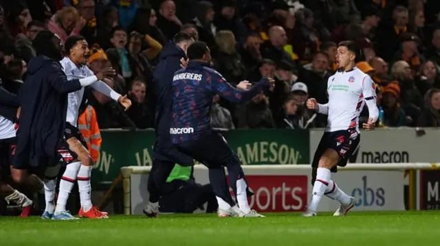 Xavier Simons celebrates with the Bolton bench