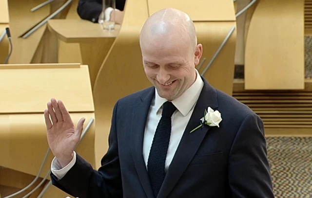 Stephen Flynn smiling as he takes his oath