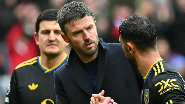 Michael Carrick shakes hands with Man Utd captain Bruno Fernandes