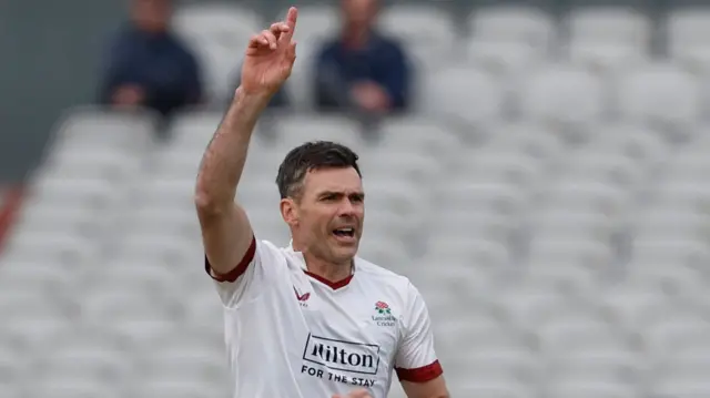 Sir James Anderson celebrating taking a wicket for Lancashire by raising his right arm with his index finger pointing upwards.