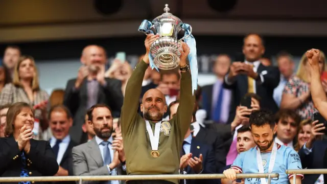 Pep Guardiola holding up the FA Cup trophy in 2023 after his side defeated Manchester United in the FA Cup final