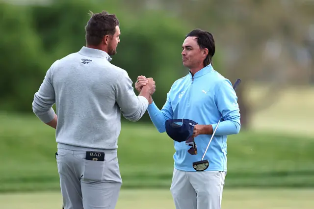 Rickie Fowler and Bryson DeChambeau embrace at the 18th
