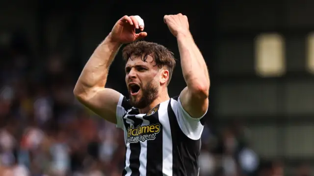 Nick Tsaroulla celebrates with his arms aloft in a Notts County home shirt