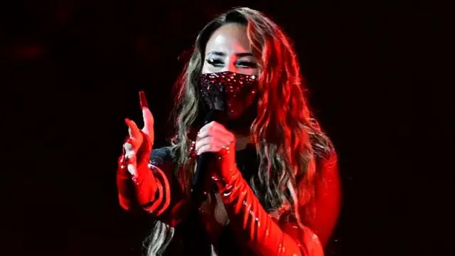 Felicia sings with a diamante mask on