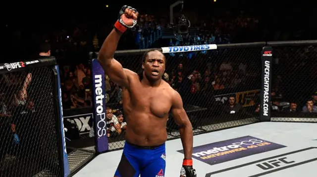 Francis Ngannou in a UFC octagon holding up his arm