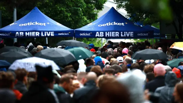 A crowd walking under tents in a massive crowd