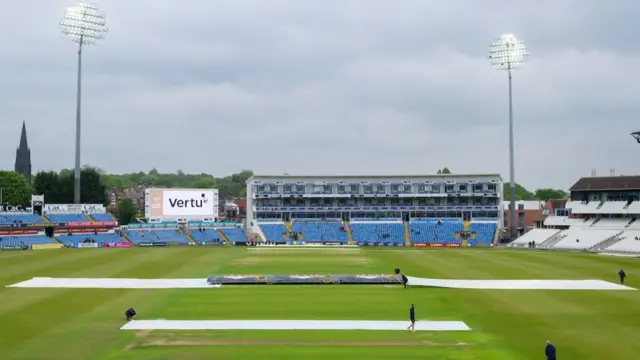 Yorkshire stadium Headingley with the covers on as well as the floodlights over gloomy skies