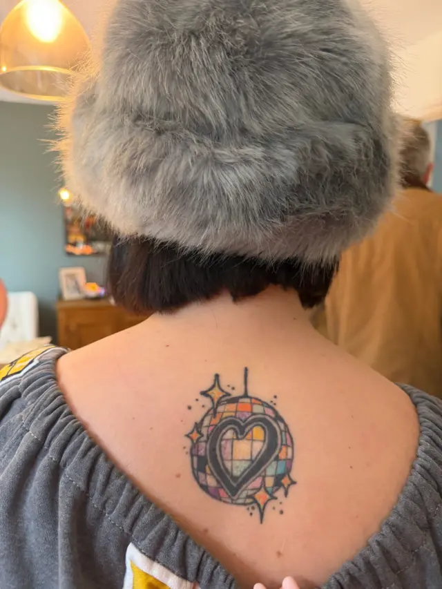 Eurovision tattoo on Chris's back, a heart on a disco ball