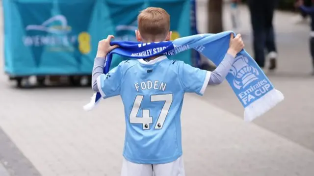 A Manchester City fan on Wembley Way ahead of the FA Cup final at Wembley Stadium wearing a Foden number 47 shirt