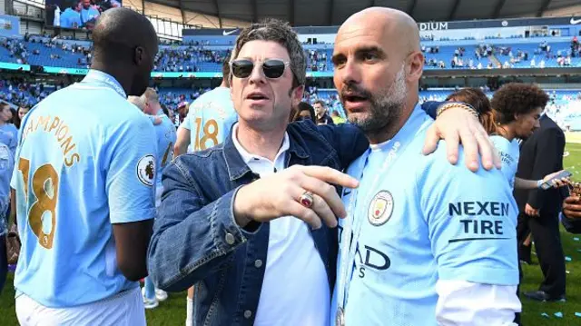 Noel Gallagher speaks to Josep Guardiola, Manager of Manchester City on the pitch