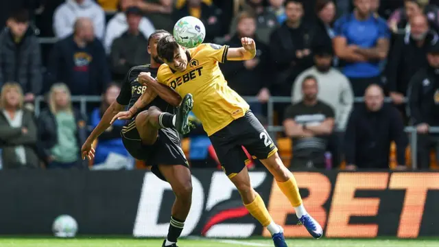 Wolverhampton Wanderers' Rodrigo Gomes competing with Fulham's Alex Iwobi during the Premier League match between Wolverhampton Wanderers and Fulham