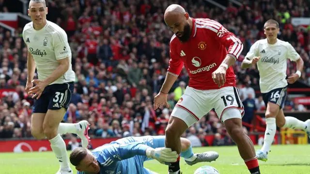 Manchester United's Cameroonian midfielder Bryan Mbeumo (R) takes the ball around Nottingham Forest's Belgian goalkeeper Matz Sels during the English Premier League football match between Manchester United and Nottingham Forest at Old Trafford
