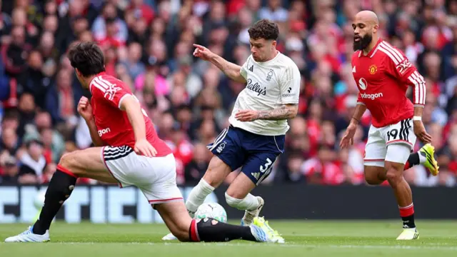 Neco Williams between two Manchester United players