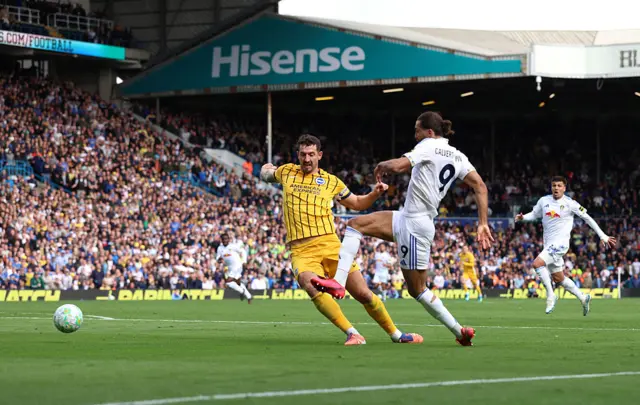 Dominic Calvert-Lewin of Leeds United scores his team's first goal while under pressure from Lewis Dunk of Brighton & Hove Albion during the Premier League match between Leeds United and Brighton & Hove Albion