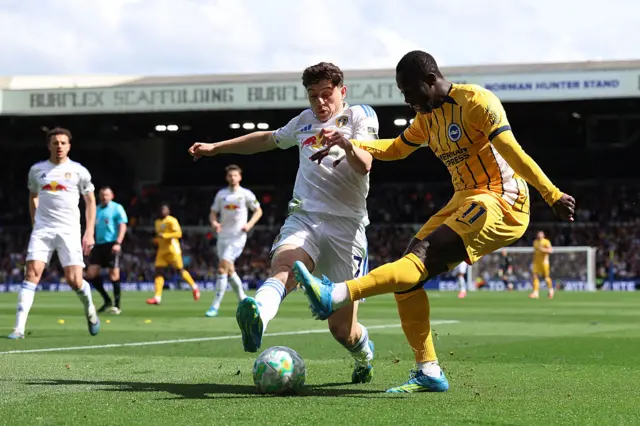 Yankuba Minteh of Brighton & Hove Albion is challenged by Daniel James of Leeds United during the Premier League match between Leeds United and Brighton & Hove Albion