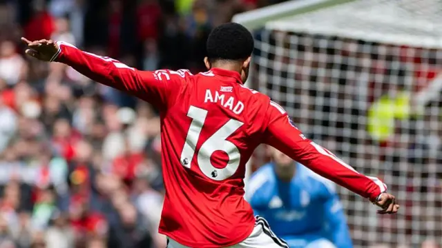 Amad goes for goal. In red jersey with white number 16 on the back.