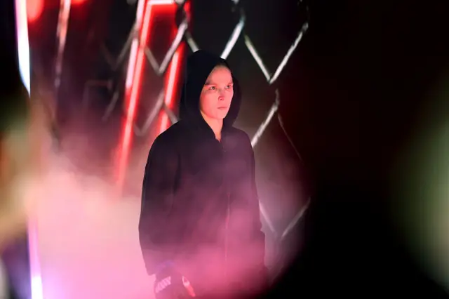 Ronda Rousey makes her entrance in a black hoodie