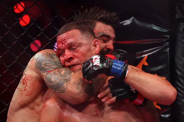 A bloodied Nate Diaz is choked by Mike Perry