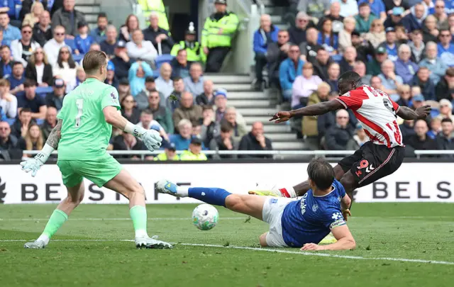 Brian Brobbey of Sunderland scores his team's first goal under pressure from James Tarkowski and Jordan Pickford of Everton during the Premier League match between Everton and Sunderland