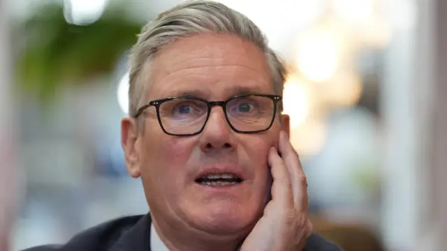A close-up shot of Keir Starmer with one hand under his chin