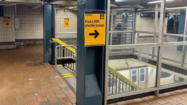 Signs pointing towards free shuttle buses inside a New York subway station