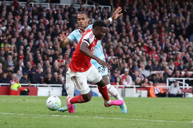 Saka goes down in the box after kicking a defender