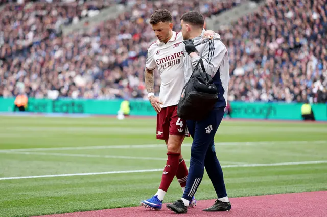 Ben White walking with Arsenal physio on the side of the pitch