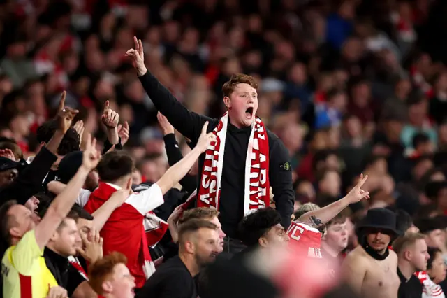 Arsenal fans cheer and chant in the stands