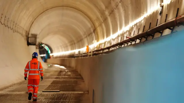 A worker heads through a HS2 tunnel in orange hi-vis