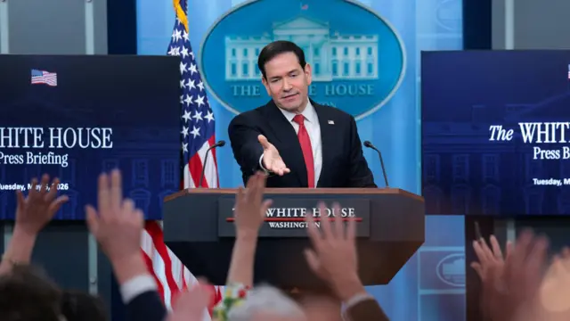 Marco Rubio gestures to press holding their hand up in the White House briefing room