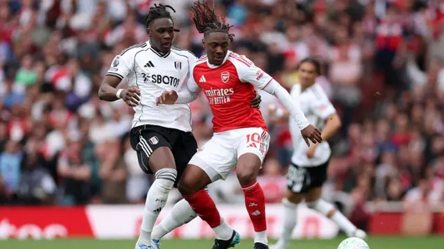 Eberechi Eze of Arsenal is challenged by Calvin Bassey of Fulham
