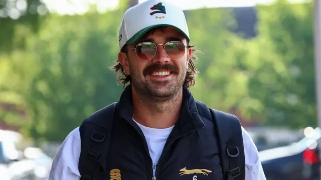 Leicestershire bowler Ben Green smiles in sunglasses and a cap
