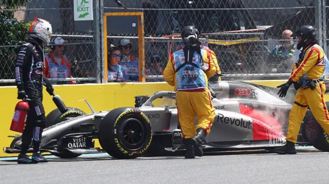 Marshals assist Nico Hulkenberg of Germany on track