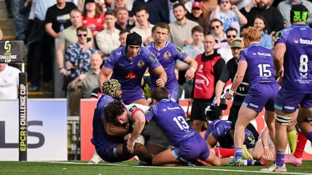 David McCann dives towards the try line with two Exeter players tackling him