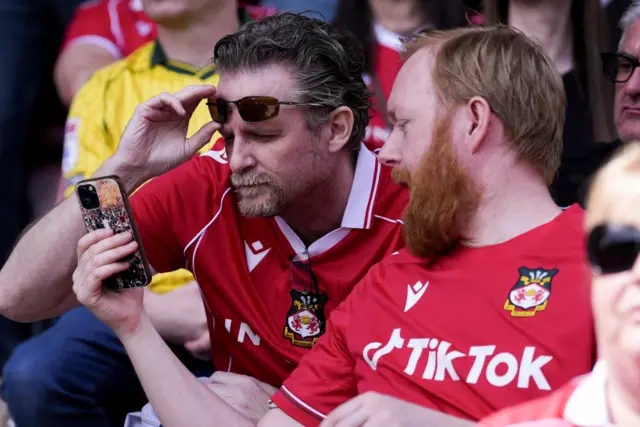 Wrexham fans check their phones