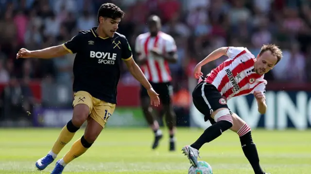 Mikkel Damsgaard controls the ball under pressure from Mateus Fernandes