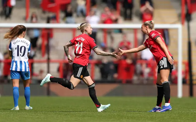 Leah Galton of Manchester United high fives teammate Ellen Wangerheim as she comes on as a substitute during the Barclays Women's Super League match between Manchester United and Brighton & Hove Albion at Progress with Unity Stadium on May 02, 2026.