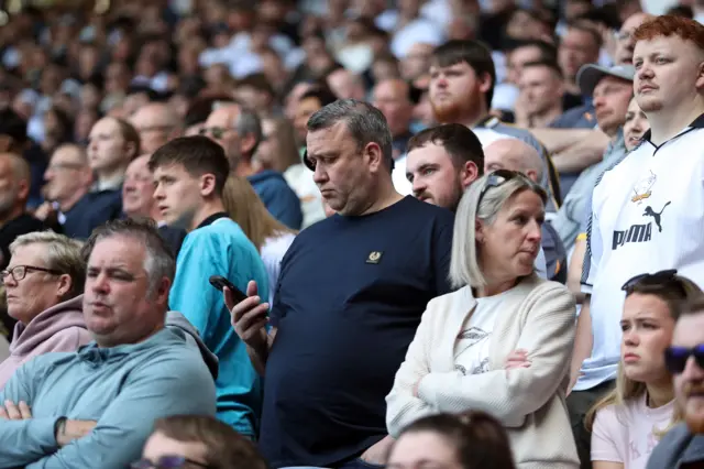 Derby fan checks his phone