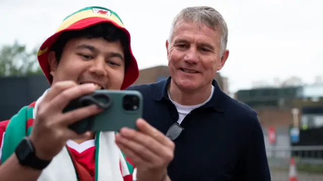 A fan takes a selfie with Wrexham boss Phil Parkinson before the game against Boro