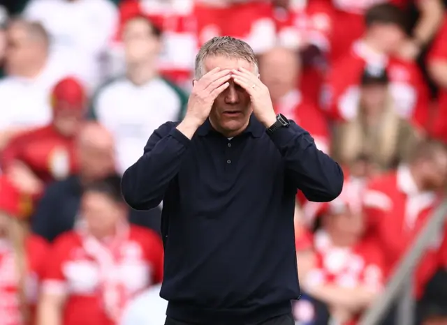 Phil Parkinson puts his hands on his head in disappointment