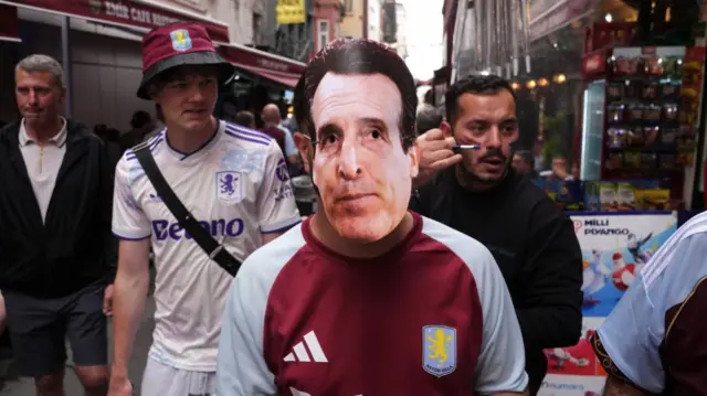An Aston Villa fan wearing a mask of manager Unai Emery in Istanbul