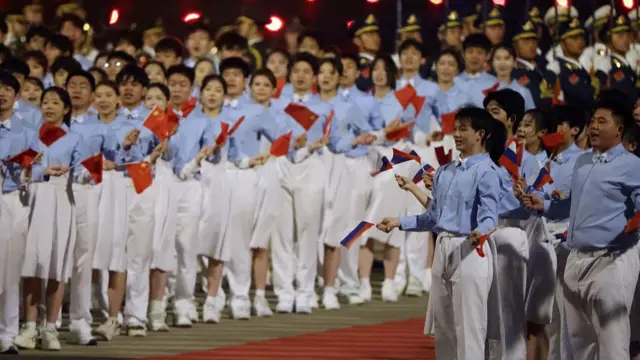 Chinese people with Russian flags greet Russian President Vladimir Putin after his arrival at the airport