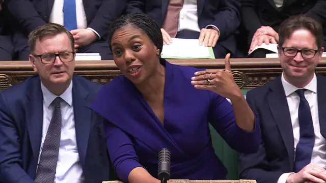 Kemi Badenoch speaks during PMQs and gestures with her left hand