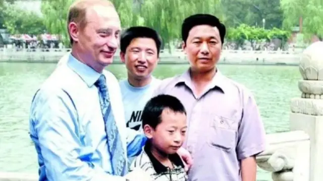 Putin posing for a photo with a young boy and two Chinese men