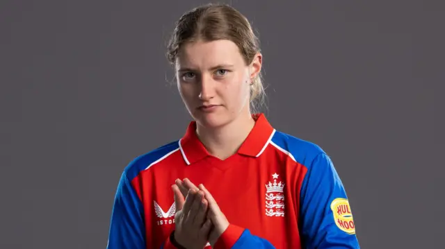Charlie Dean looking into the camera while clasping her hands