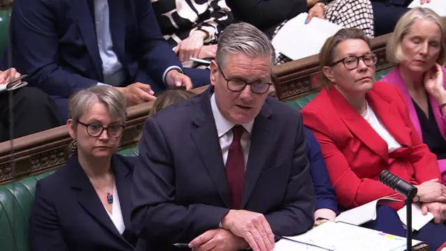 Starmer leans on the dispatch box as he speaks during PMQs