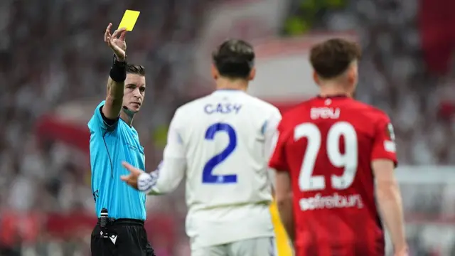 Matty Cash of Aston Villa is shown a yellow card