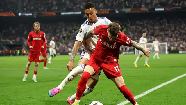 Lukas Kuebler of Sport-Club Freiburg is challenged by Morgan Rogers