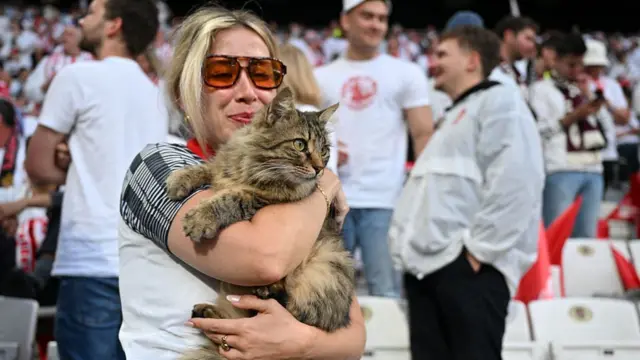 A Freiburg fan holds a cat prior to the UEFA Europa League final football match between SC Freiburg and Aston Villa at Besiktas Park in Istanbul