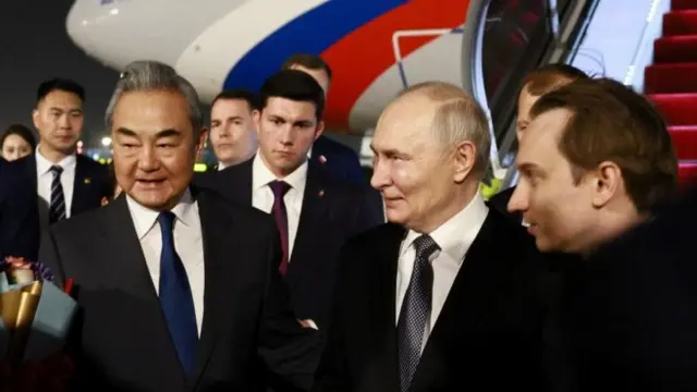 Putin (second from right) was greeted by Wang Yi